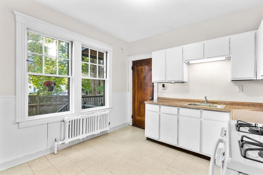 30-32 Goodrich Road Boston, MA 02130 - Photo 24 of 39 a kitchen with granite countertop white cabinets and a window