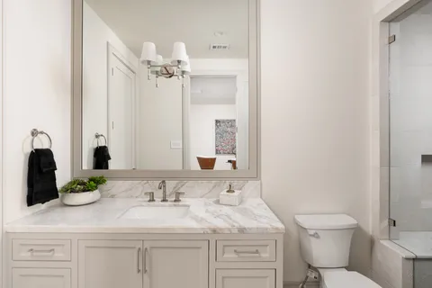 a bathroom with a sink a toilet and shower