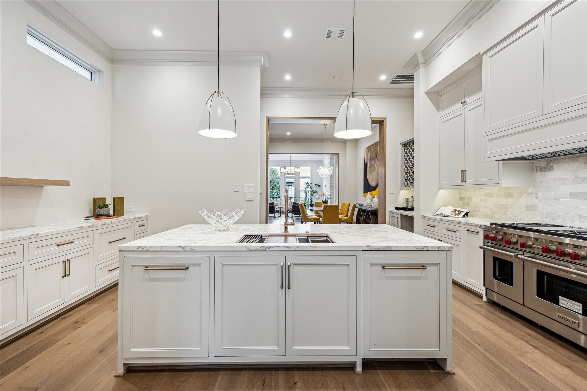 1215 West Pierce Street Houston, TX 77019 - Photo 3 of 40 The kitchen's center island features marble countertop with signature edge profile, Ruvati workstation, and a Bosch dishwasher with disappearing cabinet panel. The tumbled marble backsplash and inset, custom-built cabinetry complete the look.