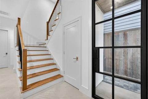 a view of a hallway with wooden floor and a staircase