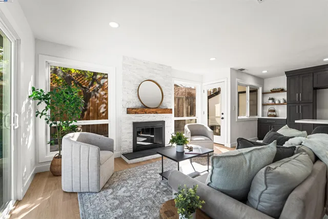 a living room with furniture a fireplace and a floor to ceiling window
