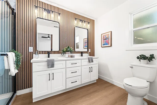 a bathroom with a toilet a sink a mirror and a window