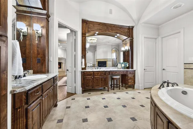 a bathroom with a sink vanity granite tub and a mirror