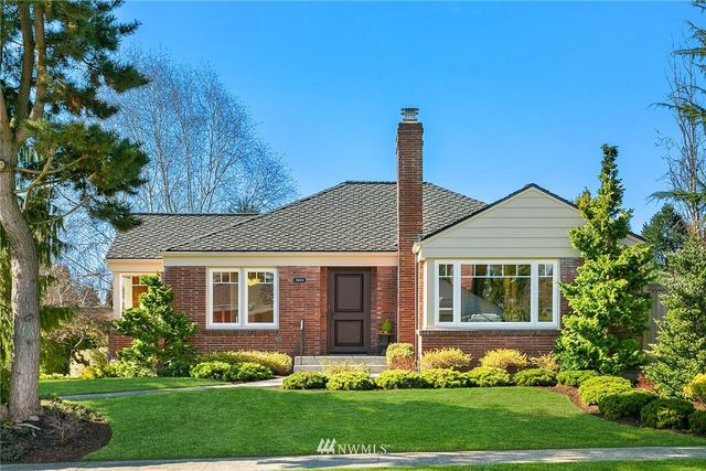 a front view of a house with a garden and plants