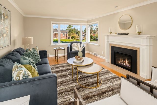 a living room with a fireplace and a painting on the wall