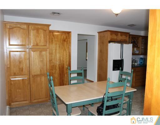 107 Oxford Road Colonia, NJ 07067 - Photo 4 of 13 a living room with a table and a refrigerator