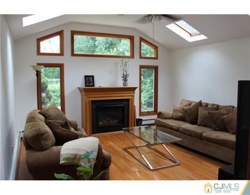 107 Oxford Road Colonia, NJ 07067 - Photo 5 of 13 a living room with furniture a large window and a fireplace