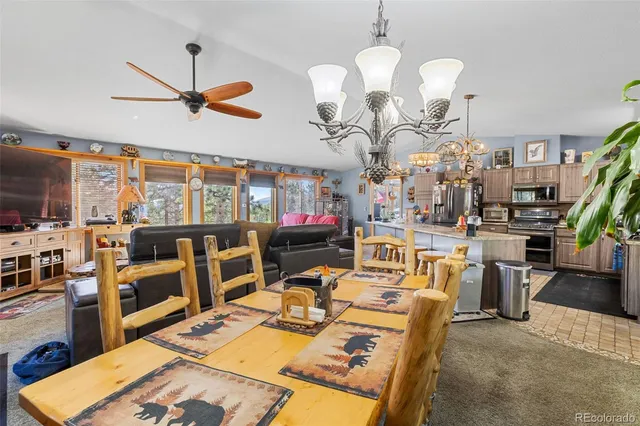 a very nice looking kitchen with granite countertop a sink a stove and chairs