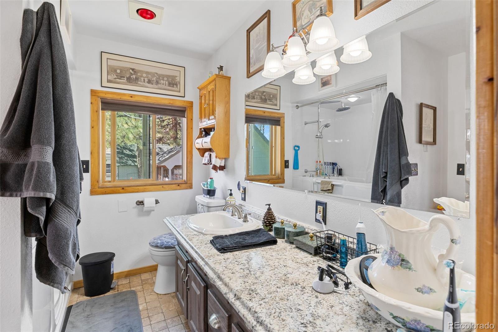 80 Fawn Road Bailey, CO 80421 - Photo 20 of 44 a bathroom with a granite countertop sink a large mirror and a window