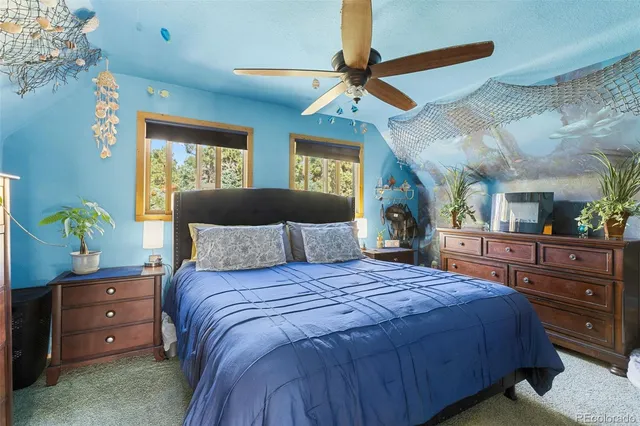 a bedroom with a bed a flat screen tv and a chandelier