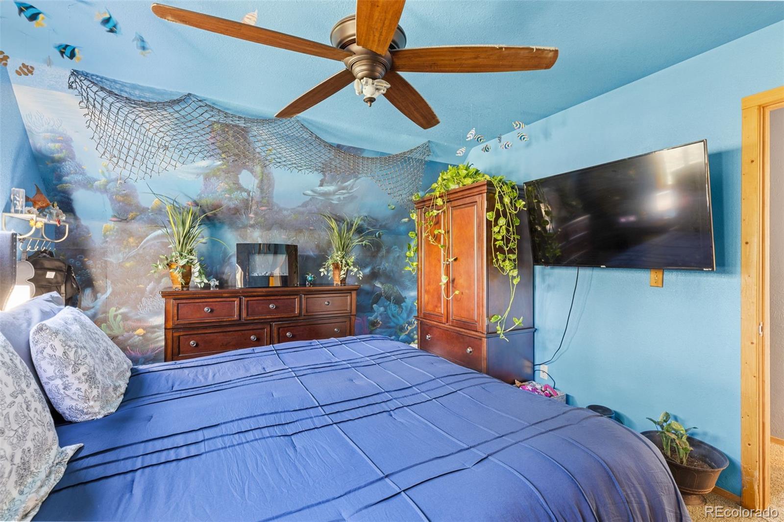 80 Fawn Road Bailey, CO 80421 - Photo 23 of 44 a bedroom with a bed a flat screen tv and a chandelier