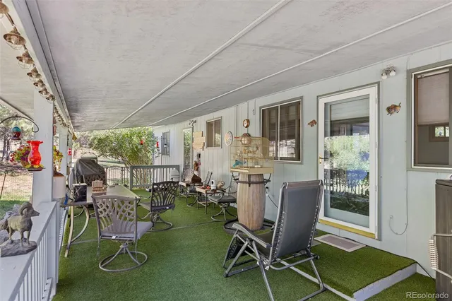 a view of a patio with a dining table and chairs with wooden fence