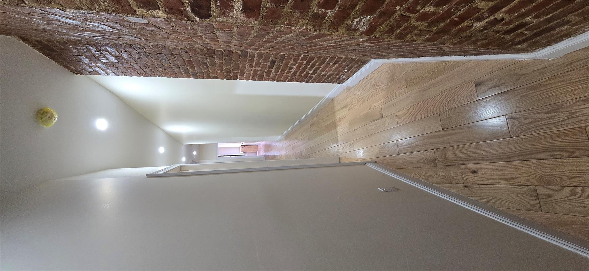 618 Riverside Drive, Unit 24 Manhattan, NY 10031 - Photo 3 of 16 Hall with brick wall, recessed lighting, light wood-style floors, and baseboards