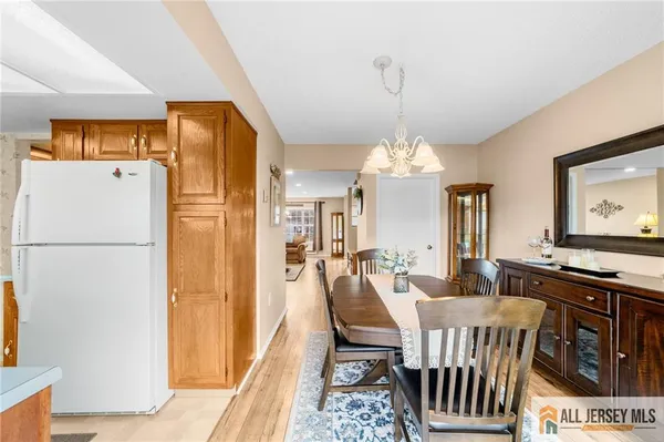 a dining room with furniture a chandelier and wooden floor