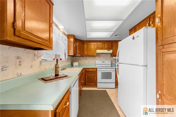 a kitchen with refrigerator a stove and a sink