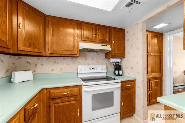 a kitchen with granite countertop cabinets stainless steel appliances and wooden floor