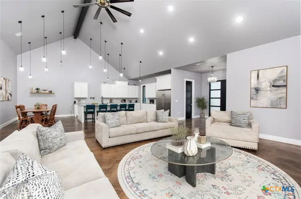a living room with furniture kitchen and a table