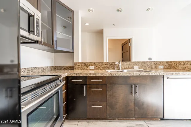 a kitchen with stainless steel appliances granite countertop a sink and a stove