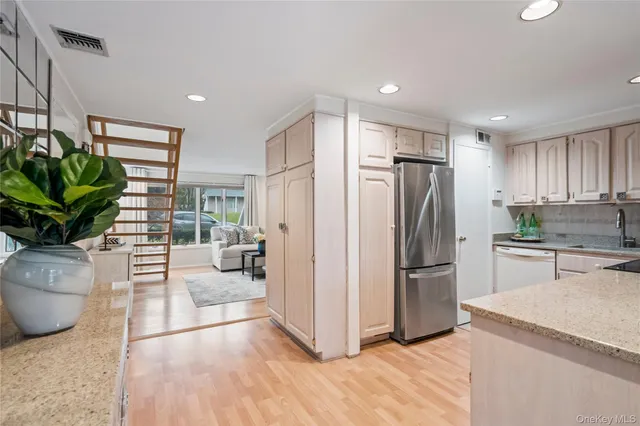 a large kitchen with stainless steel appliances kitchen island granite countertop a refrigerator and a stove top oven