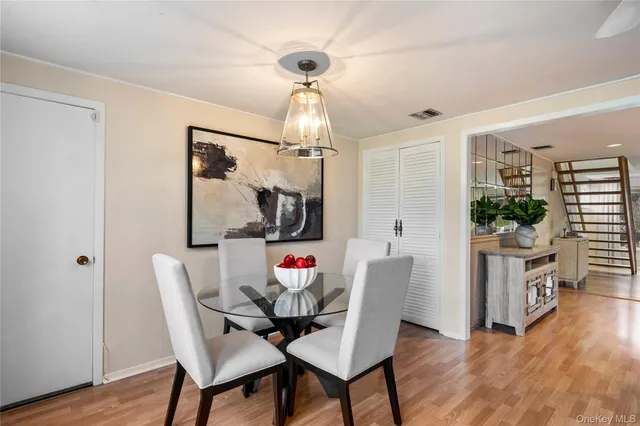a dining room with furniture a chandelier and wooden floor