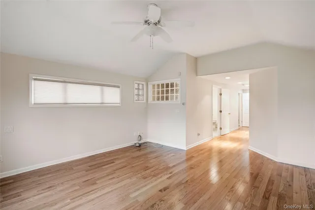 a view of a livingroom with wooden floor and a ceiling fan