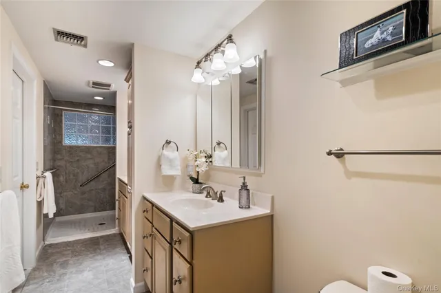 a bathroom with a sink a mirror and a shower