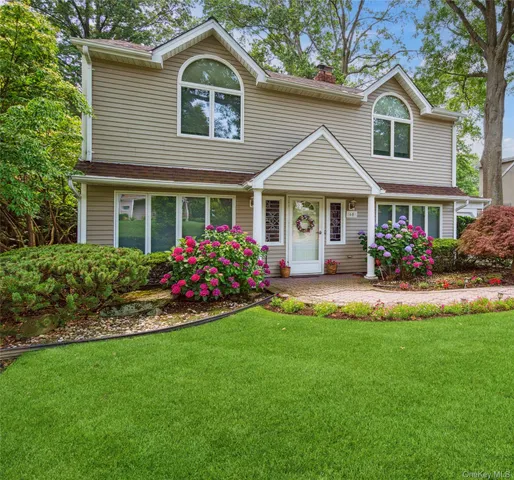 a front view of a house with a yard and potted plants