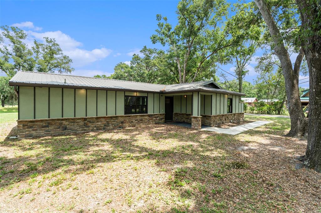 a view of a yard with a house and a large tree