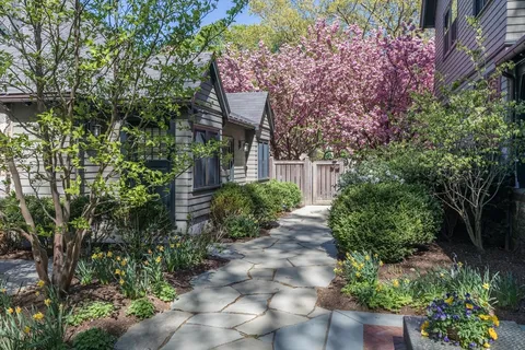 a pathway of a house with a lot of flower plants