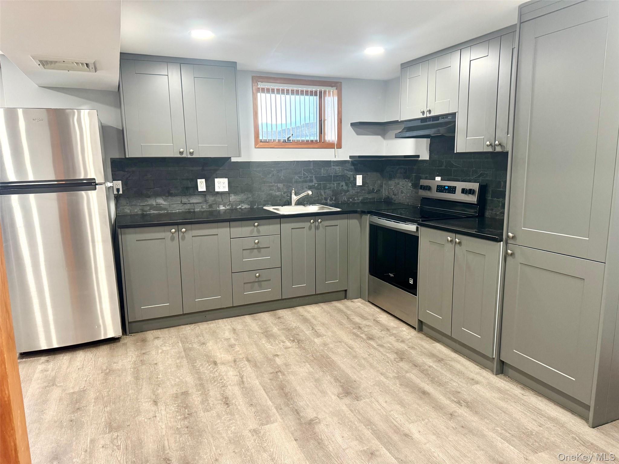 a kitchen with granite countertop stainless steel appliances a refrigerator sink and microwave