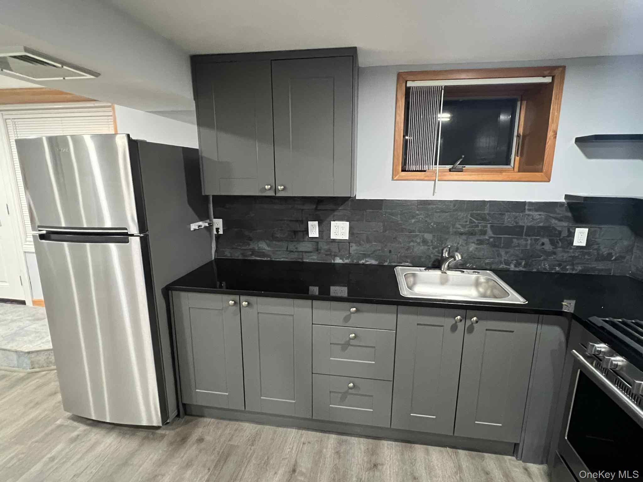 a kitchen with sink a refrigerator and cabinets