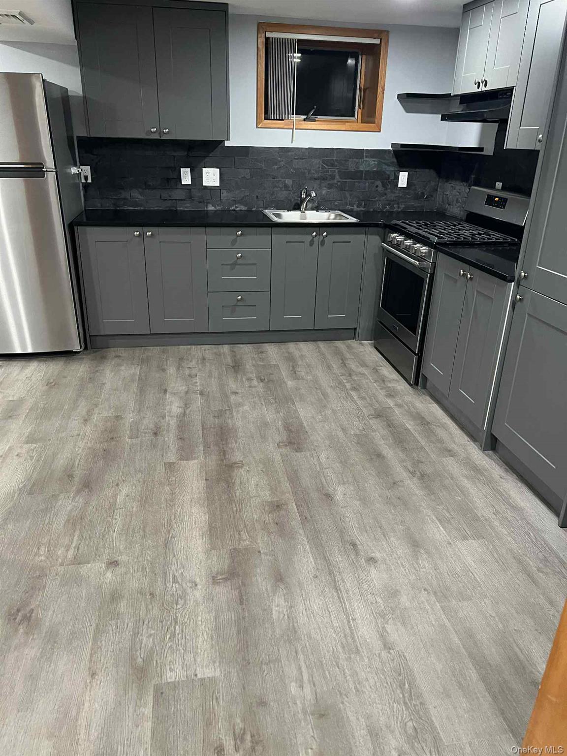 27 Blydenburgh Road Centereach, NY 11720 - Photo 4 of 11 a kitchen with granite countertop a stove and cabinets