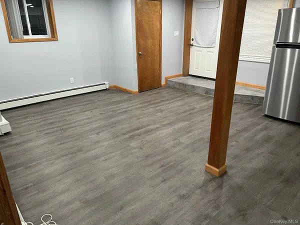 an empty room with wooden floor and a window