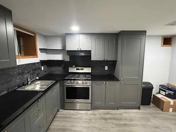 a kitchen with stainless steel appliances granite countertop a stove a sink and a microwave