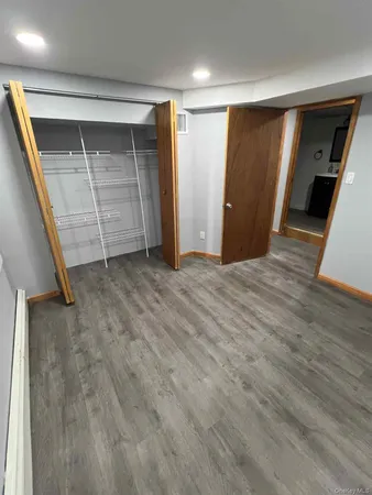 a view of an empty room with closet and stairs