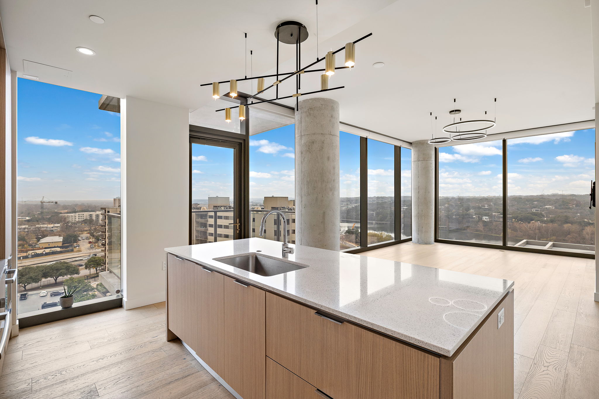 44 East Avenue, Unit 1210 Austin, TX 78701 - Photo 11 of 40 Kitchen opening to living room with light wood finish cabinetry, light wood flooring, light stone countertops, and modern cabinets