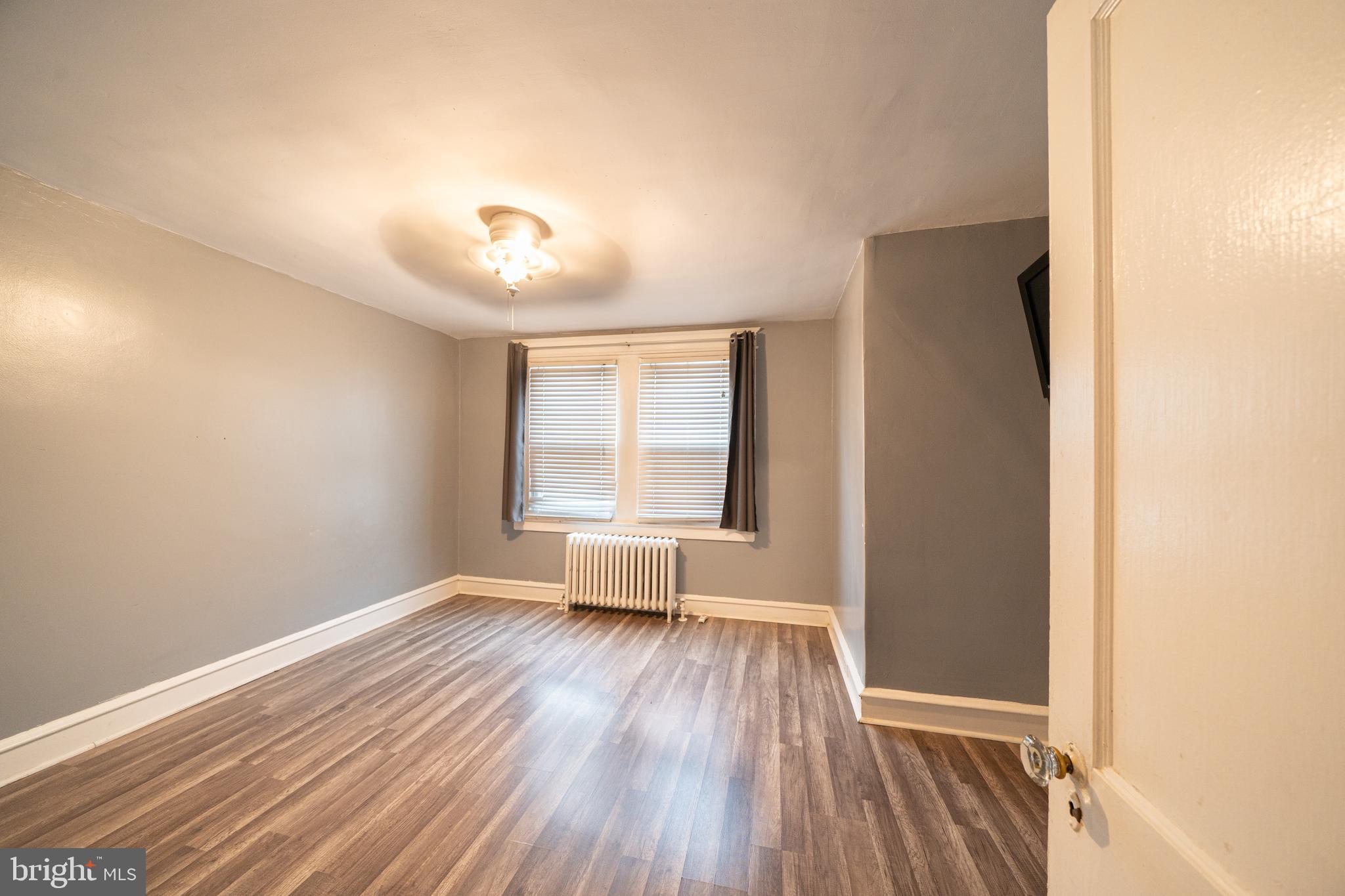 4141 Stirling Street Philadelphia, PA 19135 - Photo 13 of 24 a view of an empty room with wooden floor and a window