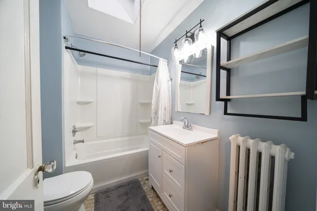 a bathroom with a granite countertop sink toilet a mirror and bathtub