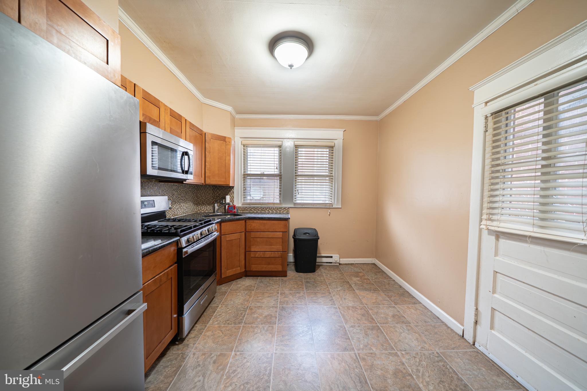 4141 Stirling Street Philadelphia, PA 19135 - Photo 6 of 24 a kitchen with stainless steel appliances granite countertop a stove and a refrigerator