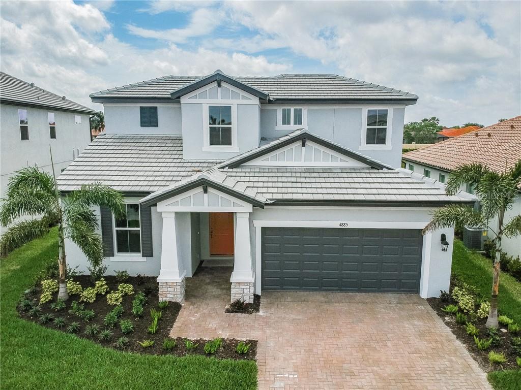 a front view of a house with a garden and plants