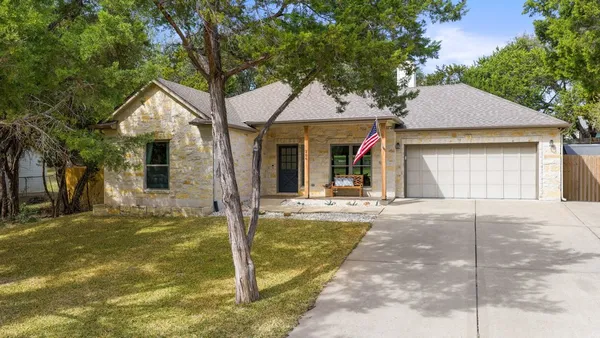 a view of a house with backyard and a tree