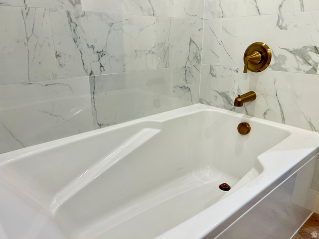 6 South 450th West Gunnison, UT 84634 - Photo 30 of 45 Bathtub featuring a white finish, bronze fixtures, and surrounding marble-look wall tiling