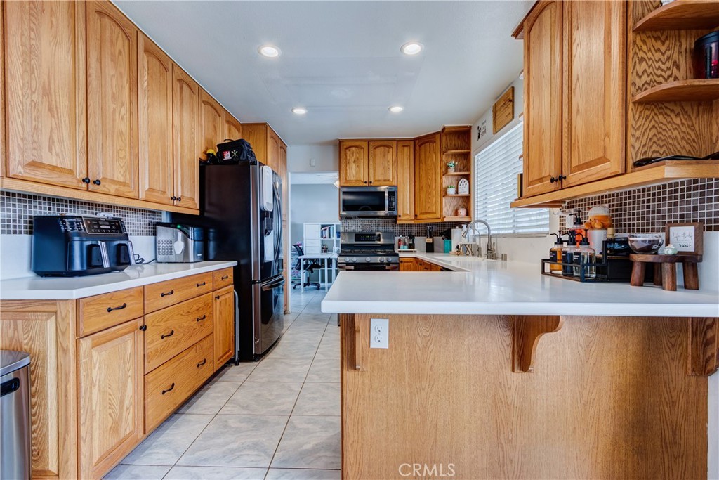 25588 Pelion Road Menifee, CA 92584 - Photo 16 of 43 a kitchen with stainless steel appliances granite countertop a refrigerator a stove and a sink