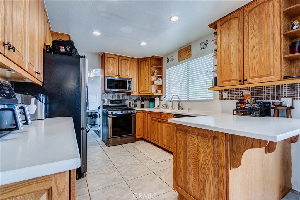 25588 Pelion Road Menifee, CA 92584 - Photo 17 of 43 a kitchen with stainless steel appliances granite countertop a refrigerator a stove top oven a sink and dishwasher