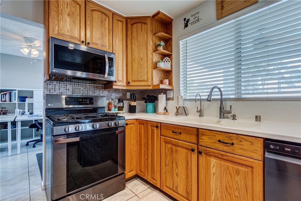 25588 Pelion Road Menifee, CA 92584 - Photo 18 of 43 a kitchen with stainless steel appliances a stove a sink and a microwave