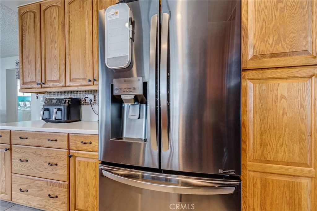 25588 Pelion Road Menifee, CA 92584 - Photo 20 of 43 a kitchen with granite countertop a refrigerator and cabinets