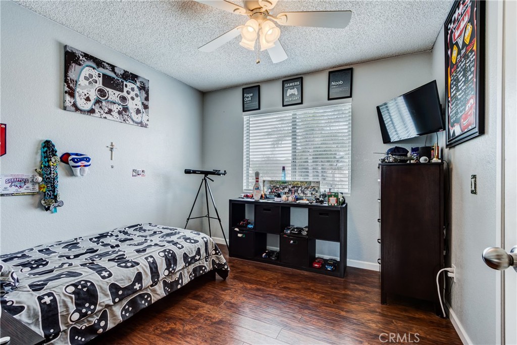 25588 Pelion Road Menifee, CA 92584 - Photo 29 of 43 a bedroom with a bed and a flat tv screen on the dresser