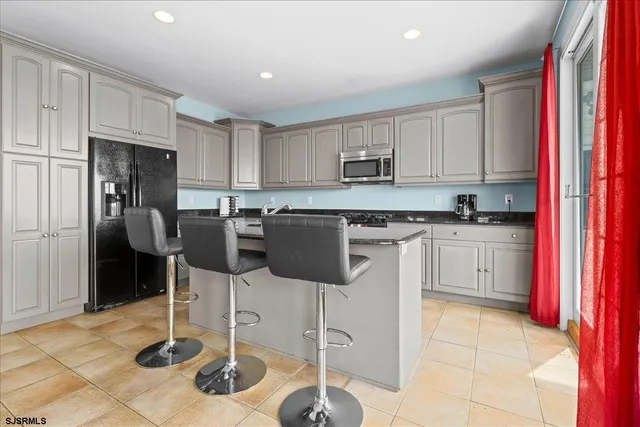 a kitchen with granite countertop white cabinets and sink