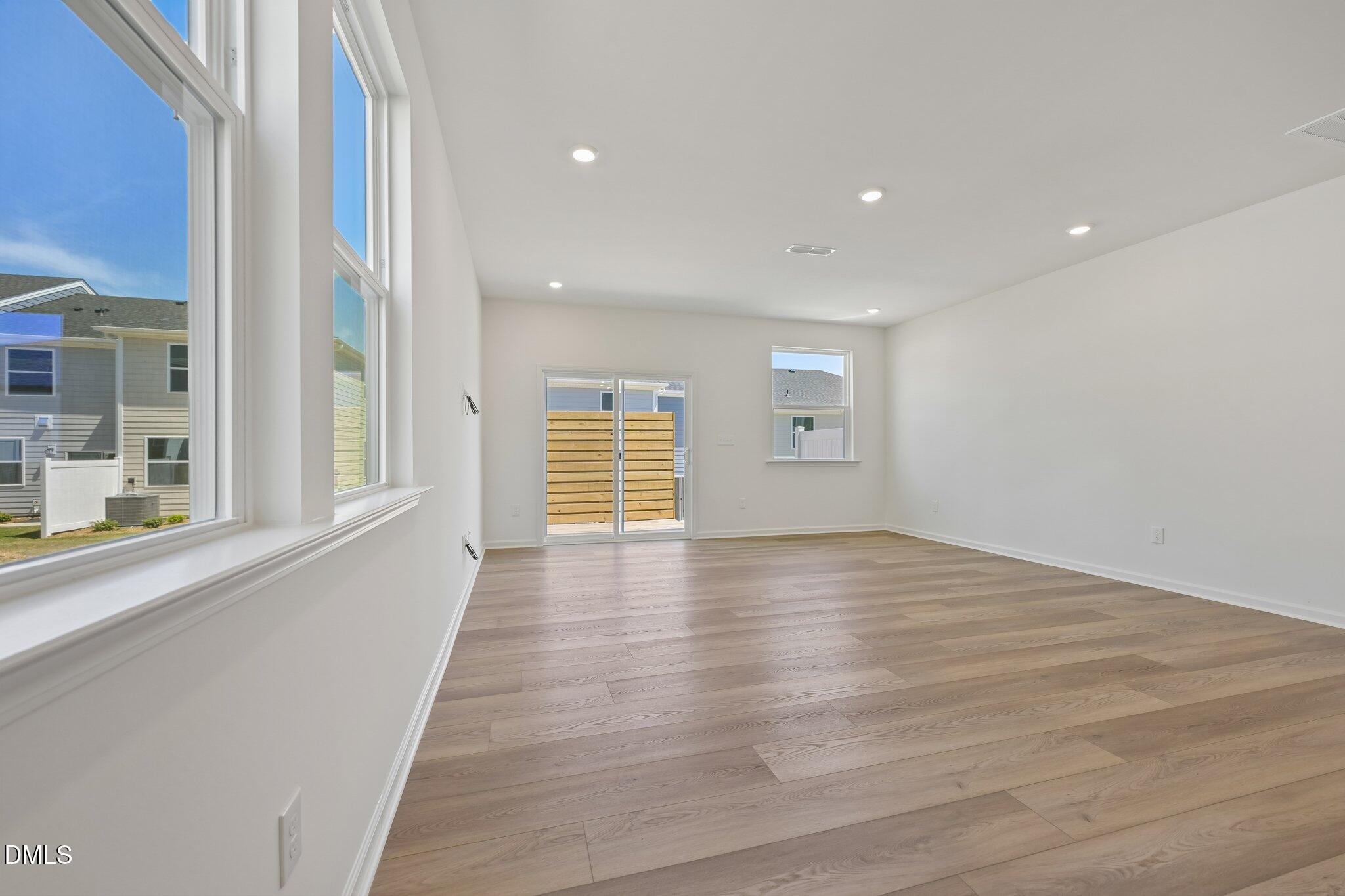 2206 Rabbitbrush Street Durham, NC 27704 - Photo 9 of 49 a view of an empty room with wooden floor and a window
