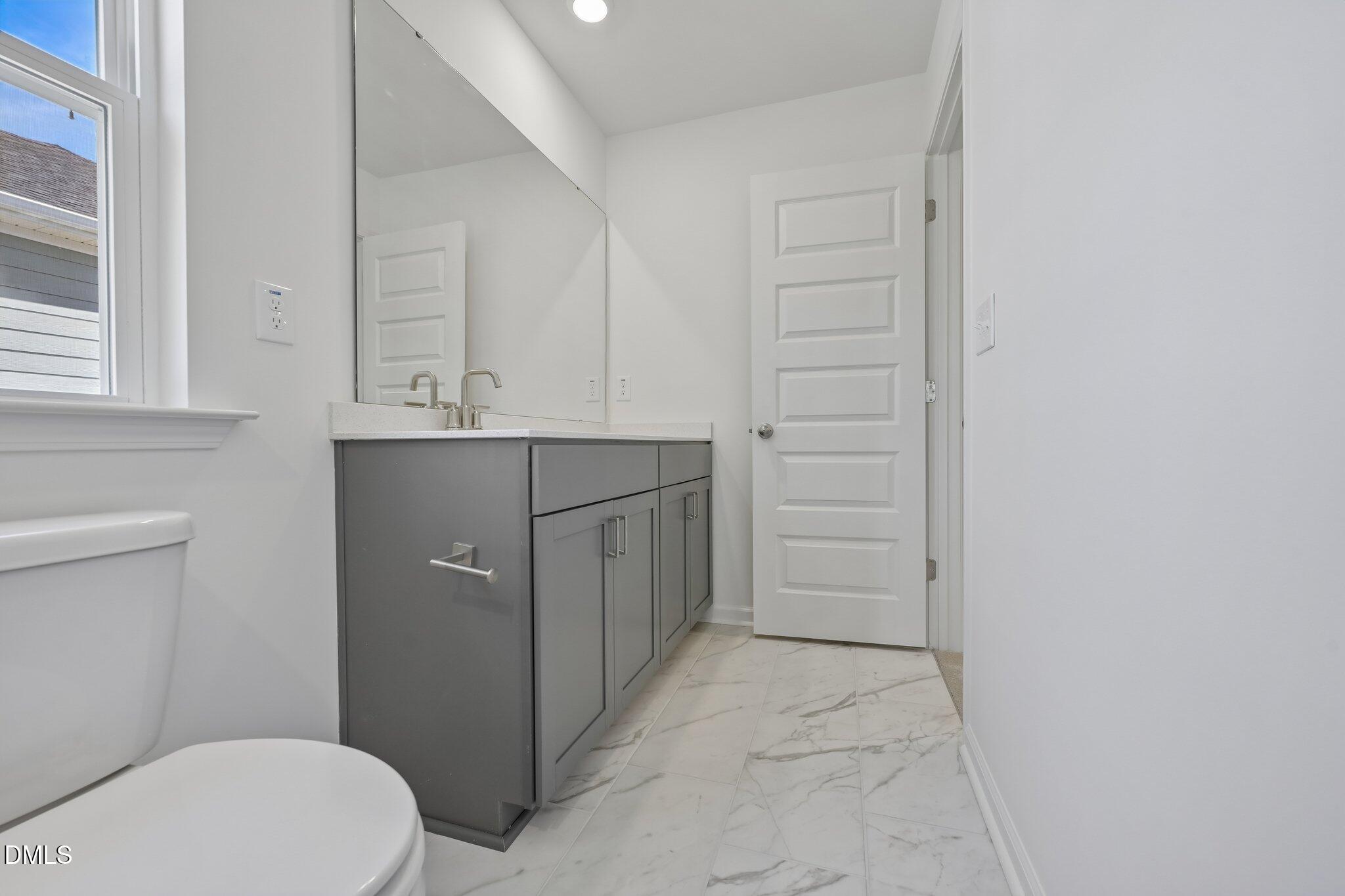 2206 Rabbitbrush Street Durham, NC 27704 - Photo 26 of 49 a bathroom with a sink a toilet and vanity